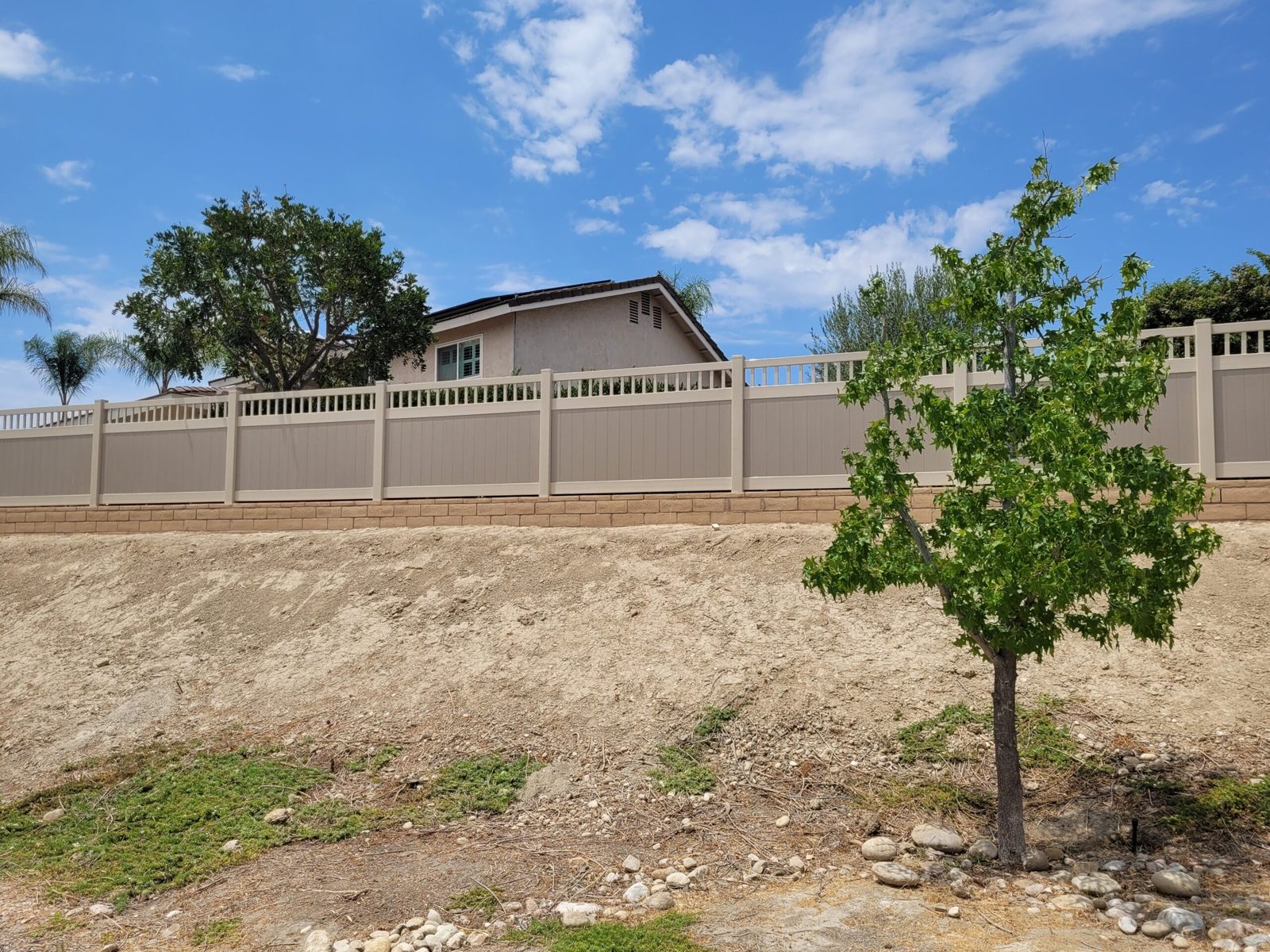 Tan vinyl privacy fence with new landscaping installed by HD Fence