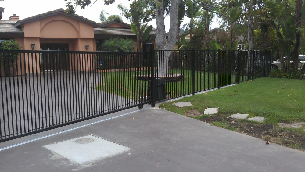 Ornamental iron driveway gate and fence line installed by HD Fence