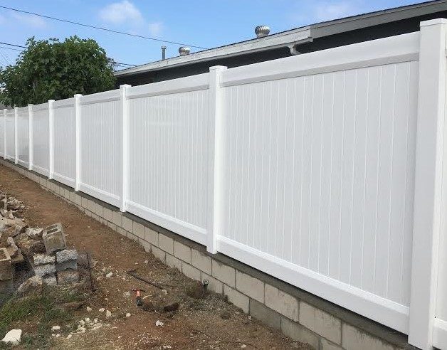 White vinyl privacy fence above a block wall