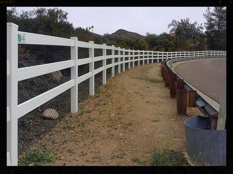 White three-rail ranch fence along a trail